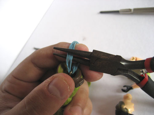 How to Fix G.I. Joe Figures with broken rubber bands: pulling the rubber band through the hips with pliers